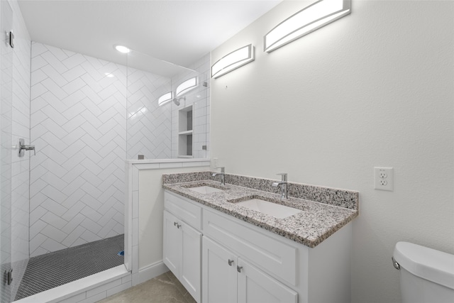 bathroom with vanity, a tile shower, and toilet