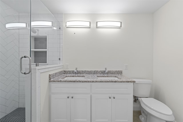 bathroom with toilet, a shower with shower door, and vanity