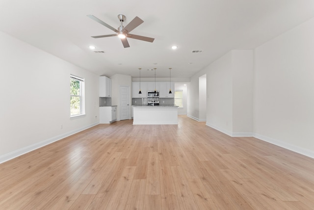 unfurnished living room with light hardwood / wood-style flooring and ceiling fan