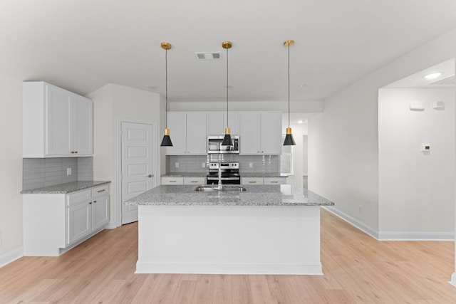 kitchen with white cabinetry, stainless steel appliances, and pendant lighting