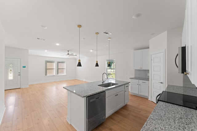 kitchen with an island with sink, white cabinetry, sink, and stainless steel appliances