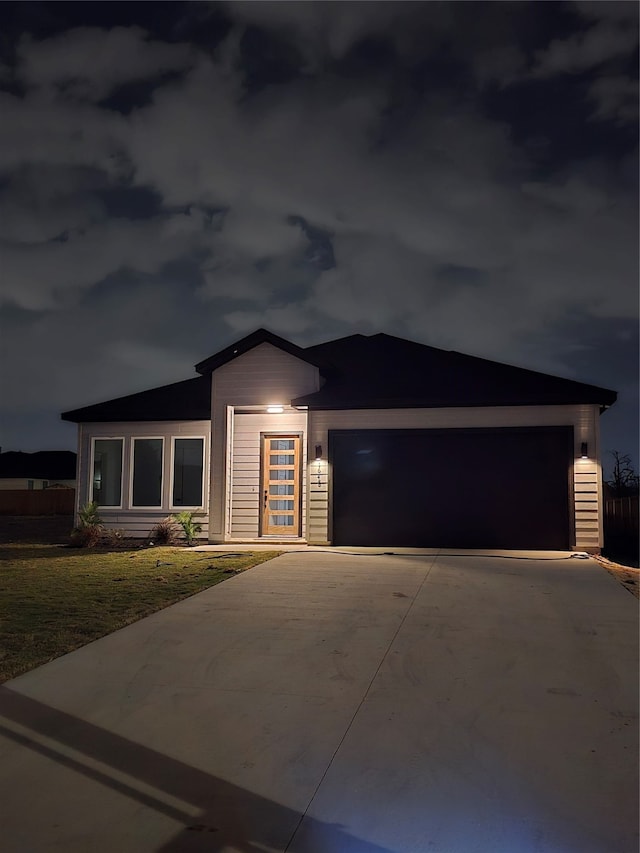 view of front of property with a front yard and a garage