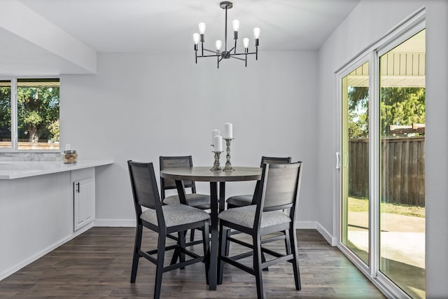 dining space with a notable chandelier, a healthy amount of sunlight, and dark hardwood / wood-style flooring