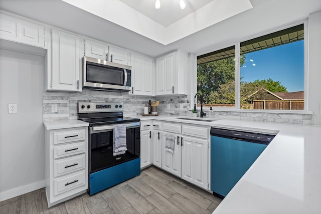 kitchen featuring sink, white cabinetry, stainless steel appliances, and light hardwood / wood-style floors