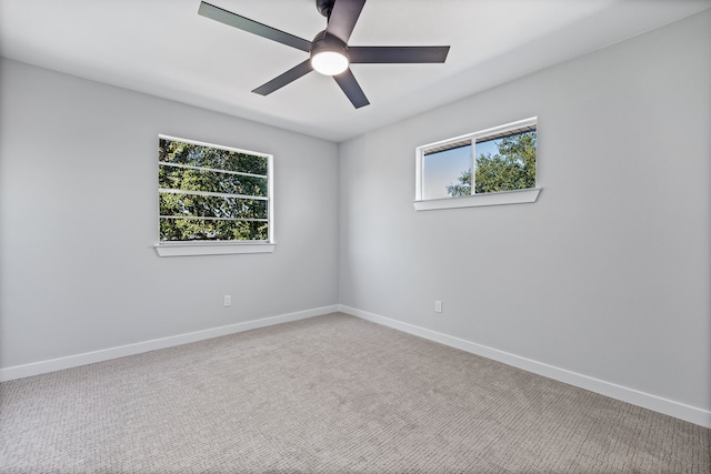 carpeted spare room with ceiling fan and a healthy amount of sunlight