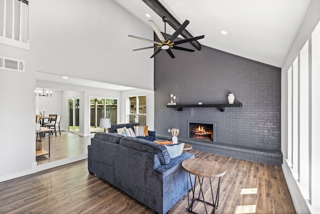 living room with dark hardwood / wood-style floors, brick wall, a brick fireplace, high vaulted ceiling, and ceiling fan