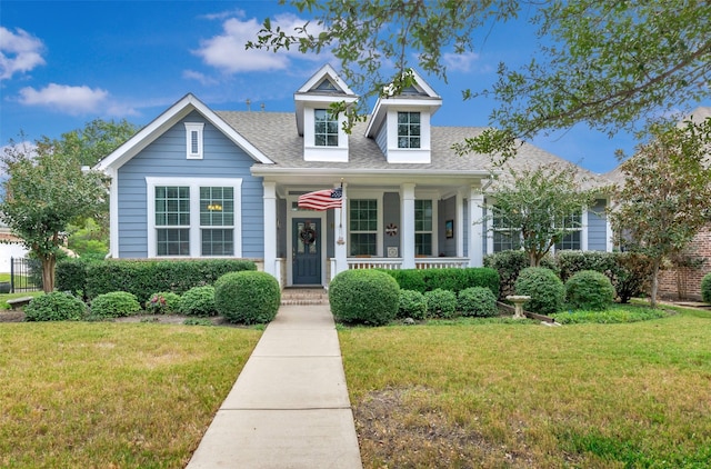 cape cod house featuring a front yard and a porch