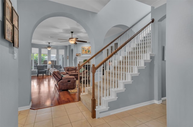 staircase with tile patterned floors and ceiling fan