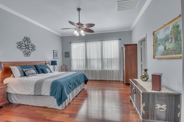 bedroom with dark wood-type flooring, ceiling fan, and crown molding