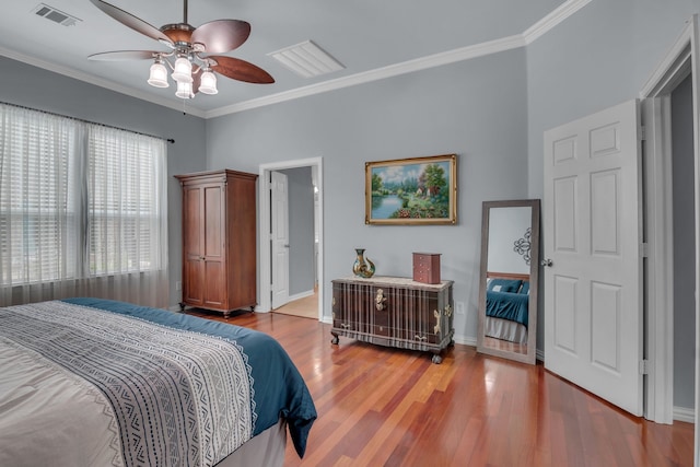 bedroom with ceiling fan, crown molding, wood-type flooring, and ensuite bathroom