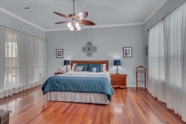 bedroom featuring ornamental molding, hardwood / wood-style floors, and ceiling fan