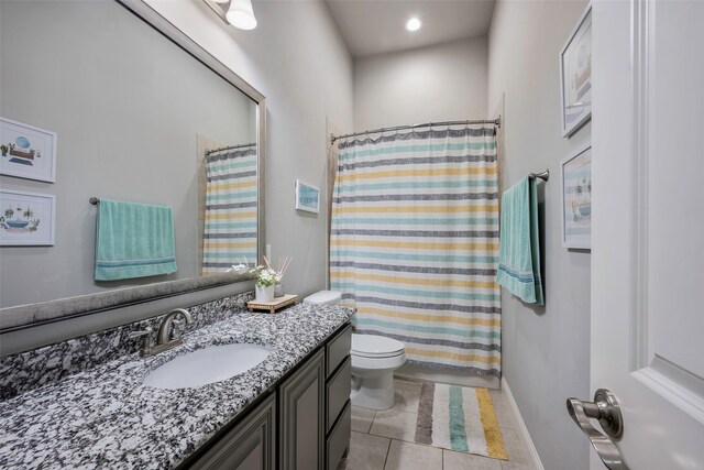 bathroom featuring vanity, toilet, walk in shower, and tile patterned flooring