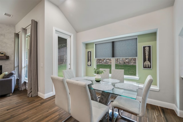 dining room with vaulted ceiling and dark hardwood / wood-style floors