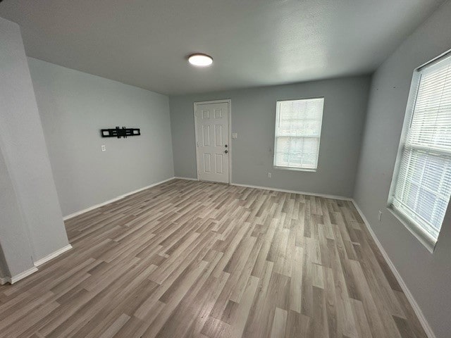 unfurnished room with light hardwood / wood-style floors and a healthy amount of sunlight