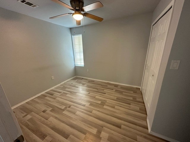 unfurnished bedroom featuring a closet, light hardwood / wood-style floors, and ceiling fan