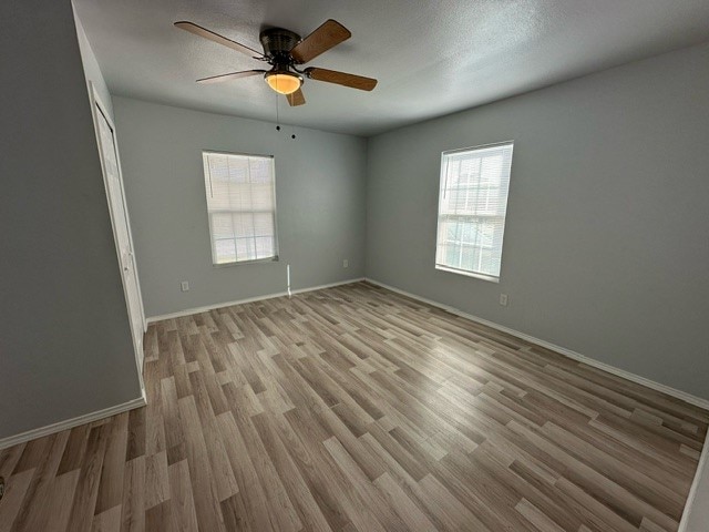 spare room with light wood-type flooring and ceiling fan