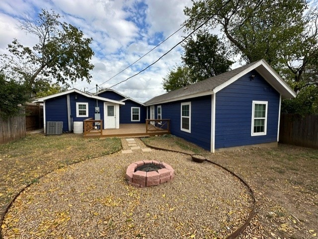 back of house with an outdoor fire pit and central AC unit