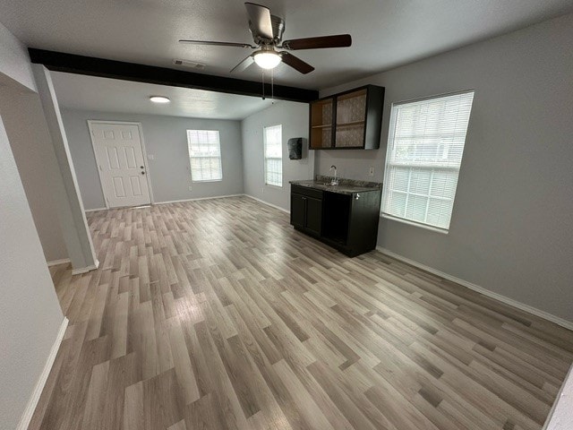 kitchen with sink, dark brown cabinets, light hardwood / wood-style floors, ceiling fan, and beamed ceiling