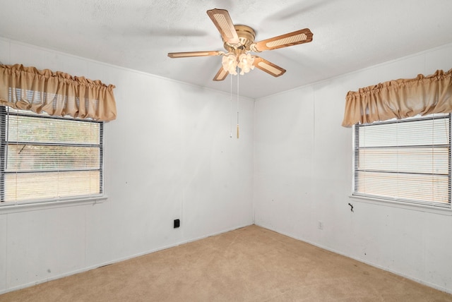 spare room with light carpet, ornamental molding, a textured ceiling, and ceiling fan