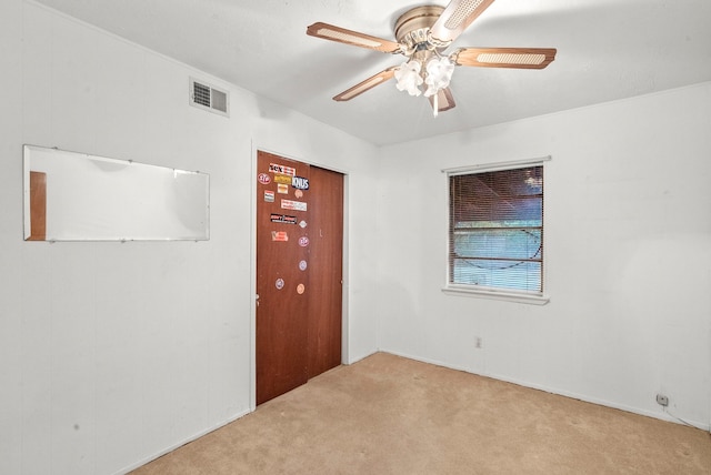 carpeted spare room featuring ceiling fan