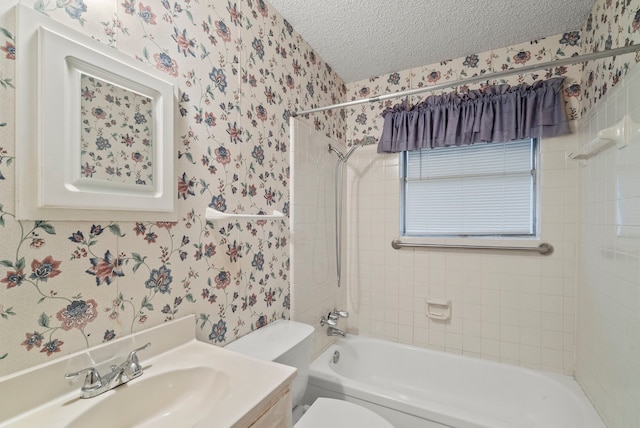 full bathroom featuring toilet, tiled shower / bath, a textured ceiling, and vanity