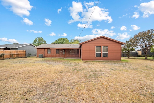 back of property featuring central air condition unit and a yard