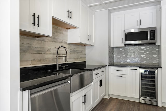 kitchen with white cabinets, tasteful backsplash, beverage cooler, appliances with stainless steel finishes, and dark hardwood / wood-style floors