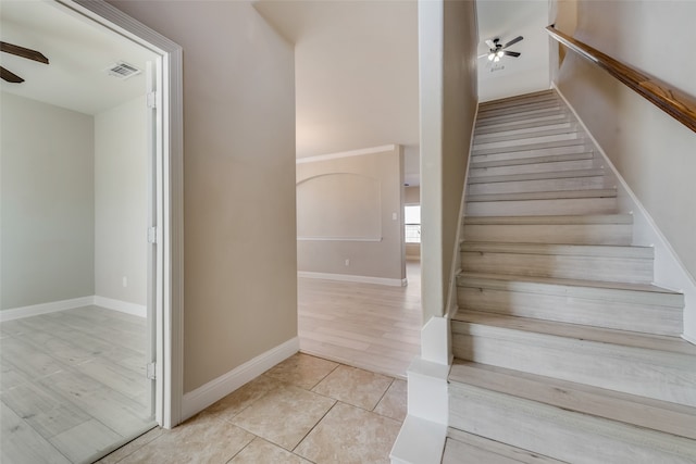 stairway featuring wood-type flooring and ceiling fan