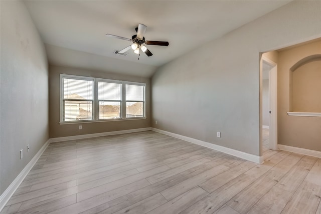 spare room featuring light hardwood / wood-style flooring, vaulted ceiling, and ceiling fan