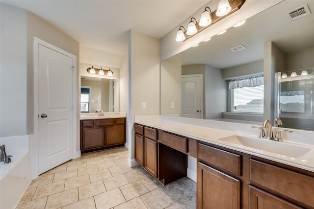 bathroom featuring vanity, tile patterned flooring, and a washtub