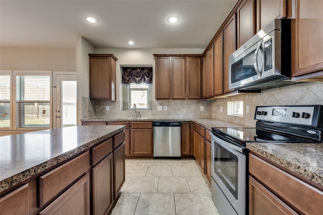 kitchen with a healthy amount of sunlight, stainless steel appliances, and decorative backsplash