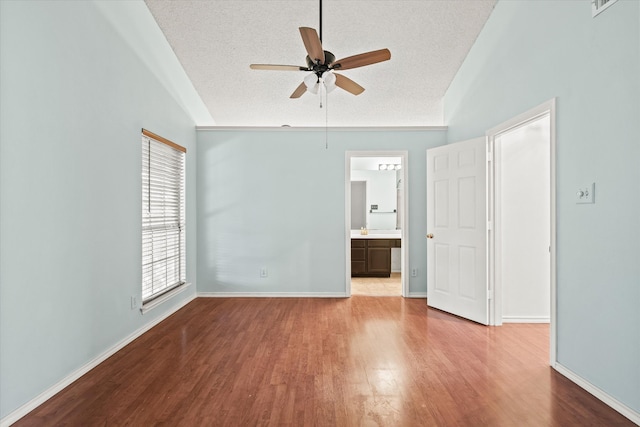 unfurnished room with light hardwood / wood-style floors, a textured ceiling, vaulted ceiling, and ceiling fan