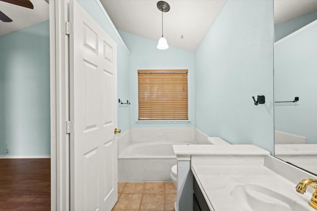 bathroom featuring toilet, wood-type flooring, vaulted ceiling, a bathing tub, and vanity