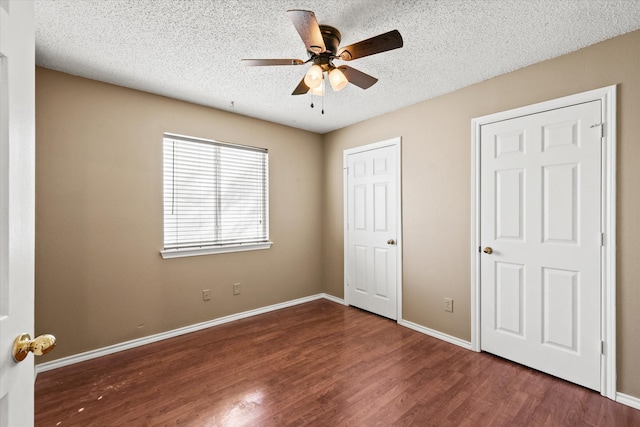 unfurnished bedroom with dark hardwood / wood-style floors, a textured ceiling, and ceiling fan