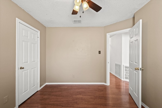 unfurnished room featuring ceiling fan, a textured ceiling, and dark hardwood / wood-style floors