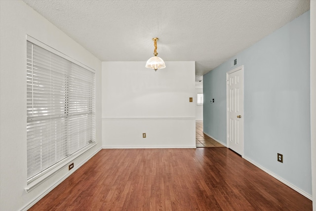 empty room featuring dark wood-type flooring and a textured ceiling