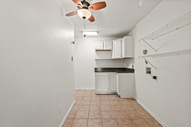 clothes washing area featuring ceiling fan, washer hookup, light tile patterned floors, and cabinets