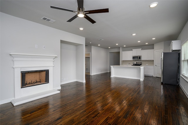 103 S Crestside Dr, Blue Ridge, TX 75424 - unfurnished living room featuring ceiling fan, visible vents, a fireplace with raised hearth, recessed lighting, and dark wood-type flooring