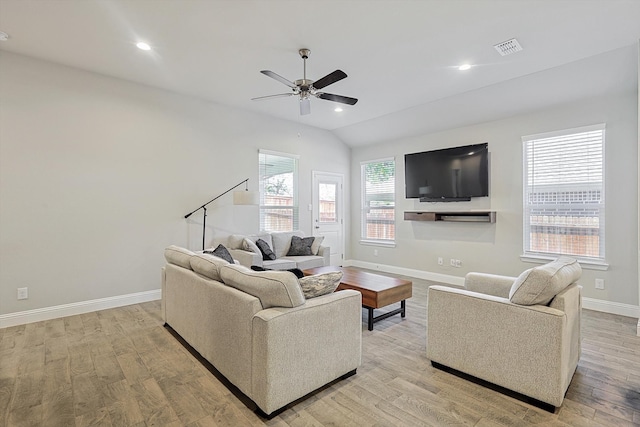 living room featuring ceiling fan, vaulted ceiling, and light wood-type flooring