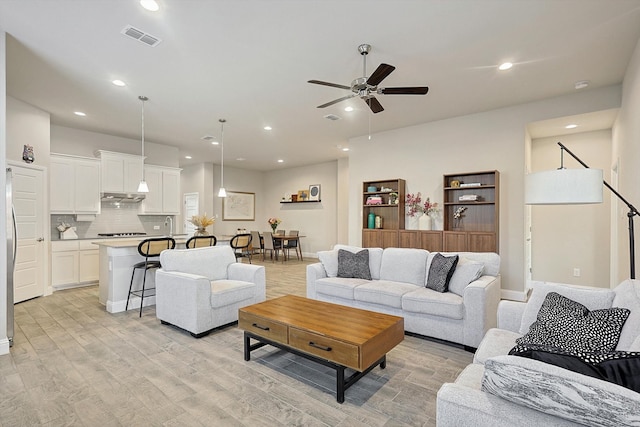 living room featuring light hardwood / wood-style flooring and ceiling fan