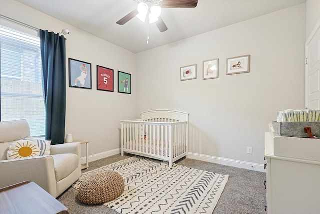 bedroom with light carpet, a nursery area, and ceiling fan