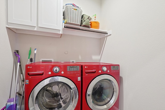 clothes washing area with cabinets and separate washer and dryer