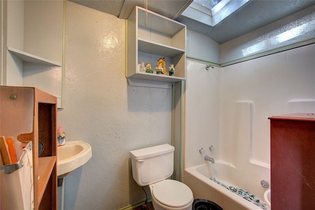 bathroom featuring a skylight, shower / bathing tub combination, and toilet