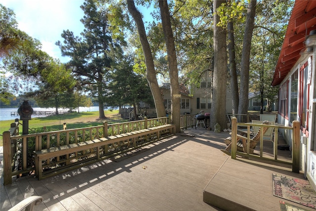 wooden deck with a water view and area for grilling