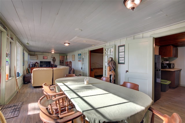 dining space with wood ceiling, a wall mounted AC, and light hardwood / wood-style floors