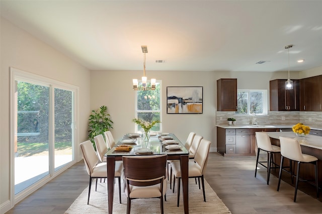 dining room featuring a chandelier, sink, and light hardwood / wood-style floors