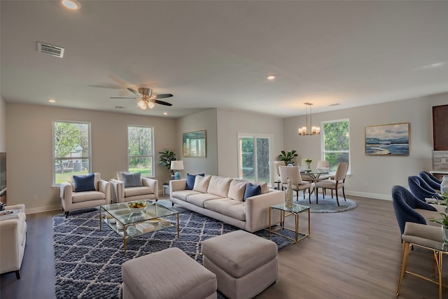 living room featuring hardwood / wood-style flooring and ceiling fan with notable chandelier