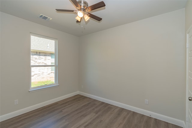 spare room featuring ceiling fan, dark hardwood / wood-style floors, and plenty of natural light