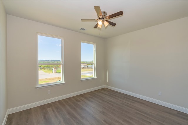 spare room with dark hardwood / wood-style flooring and ceiling fan