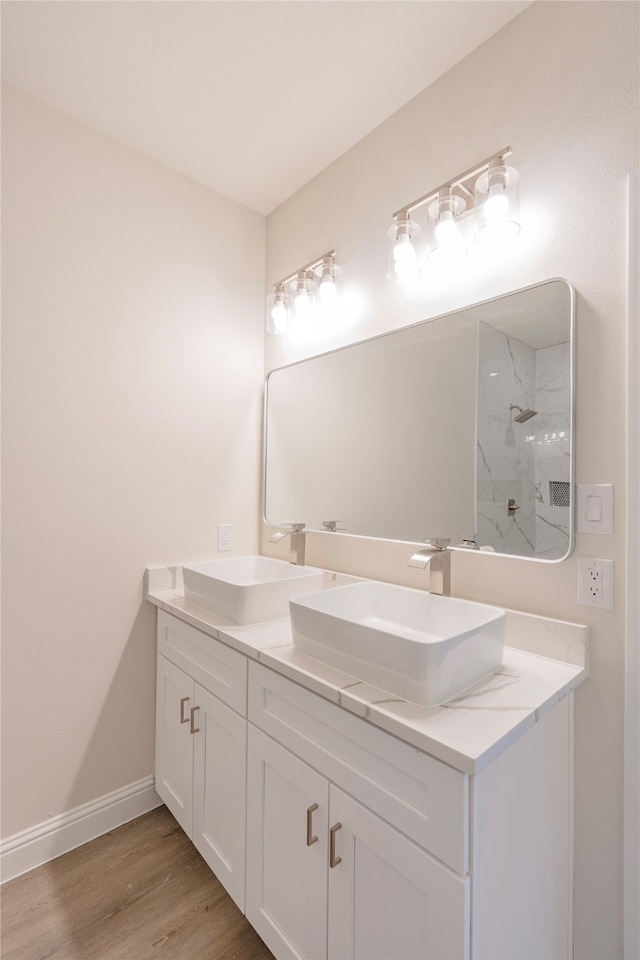 bathroom with hardwood / wood-style floors, walk in shower, and vanity